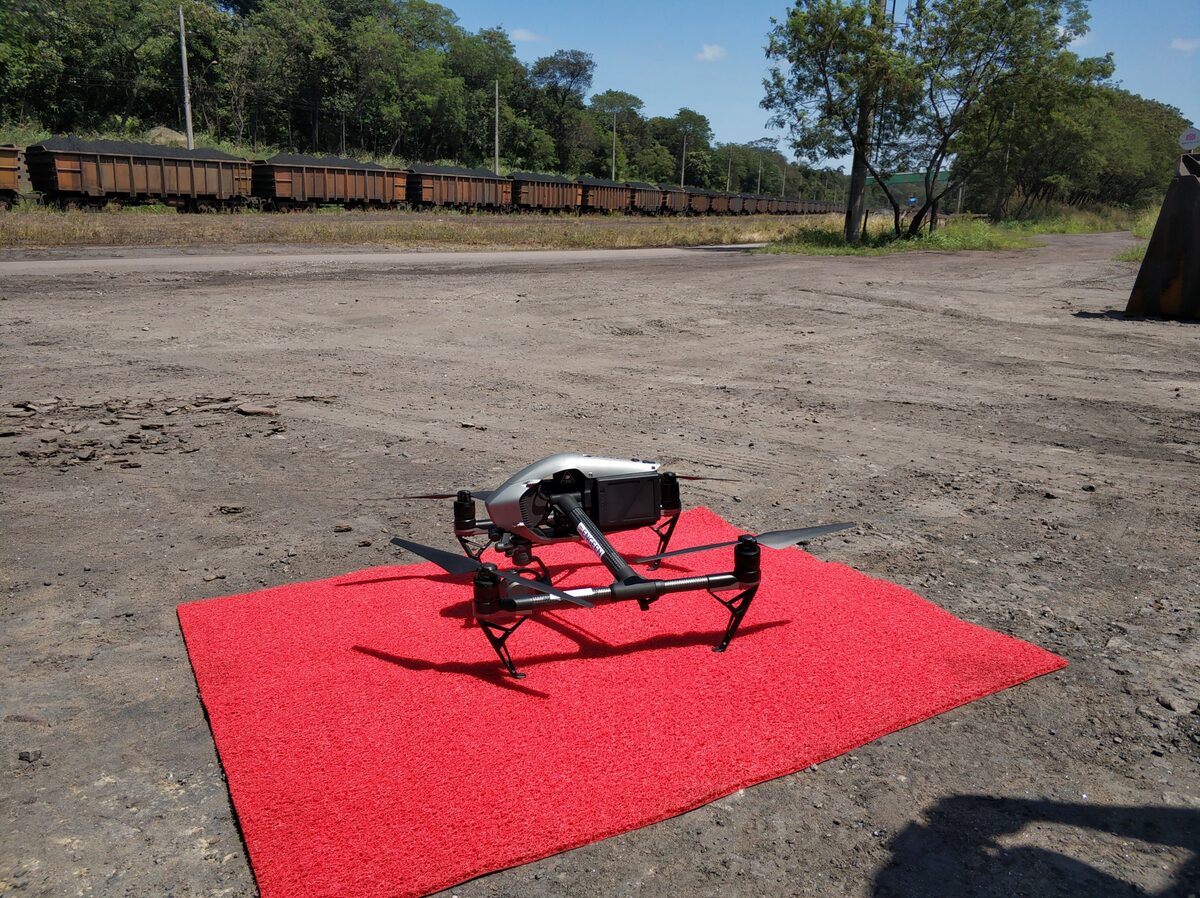 Drone em plataforma de pouso com vagões ferroviários ao fundo